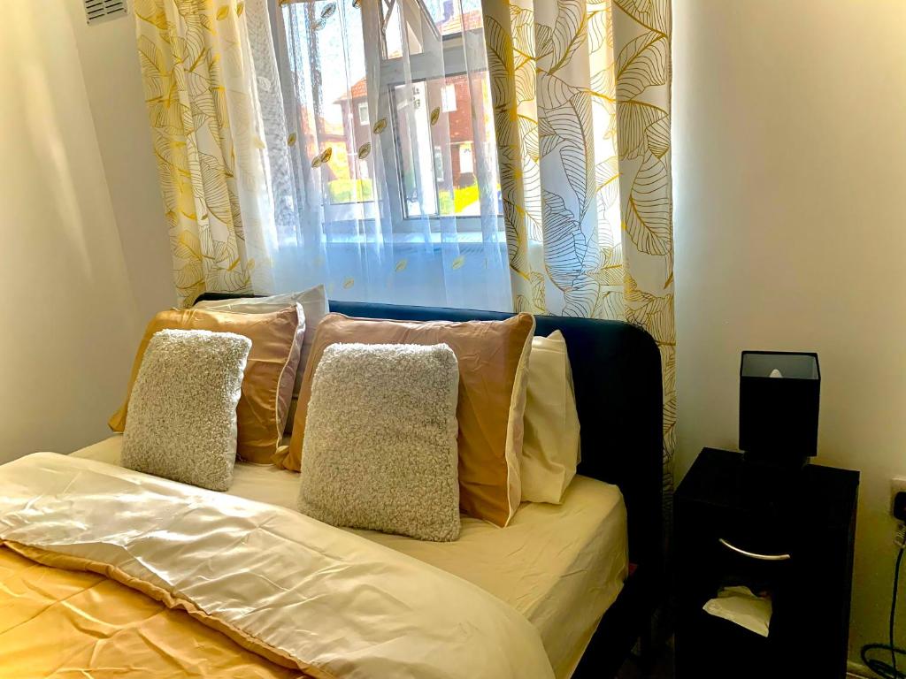 uma cama com almofadas sentadas em frente a uma janela em Double room bentilee em Bucknall