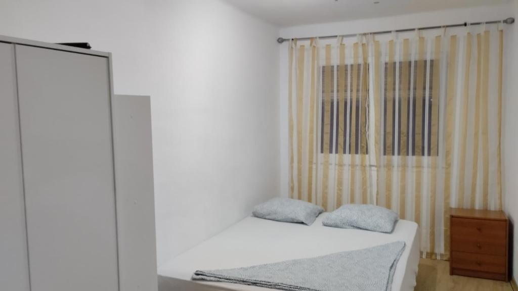 a bedroom with a bed with two pillows on it at metro La Salut in Badalona