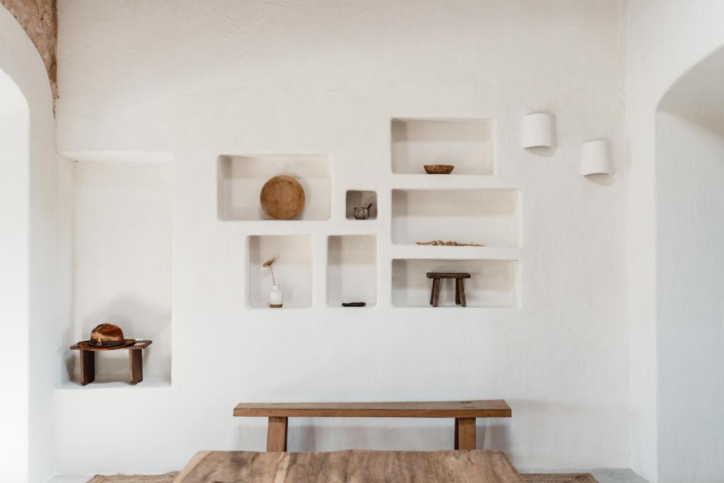 Habitación con mesa de madera y paredes blancas. en Aguamadera, en Santa Eulària des Riu
