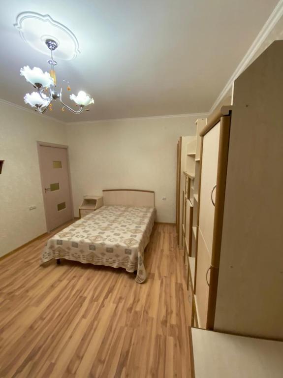 een slaapkamer met een bed in een kamer met houten vloeren bij Studio apartment in Jechegnadzor