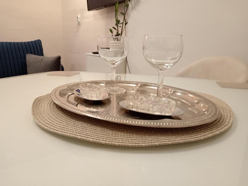 a silver plate with two wine glasses on a table at Red Square Apartment in Pirot