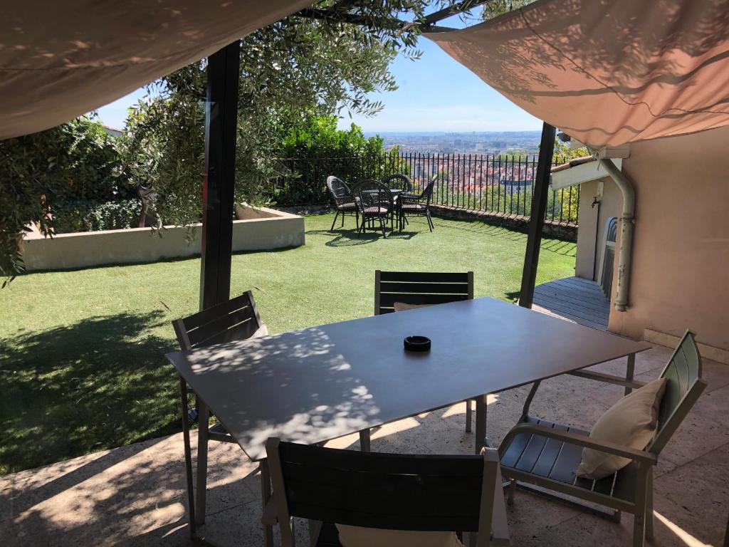 a table and chairs on a patio with a view at Le Gourguillon in Lyon