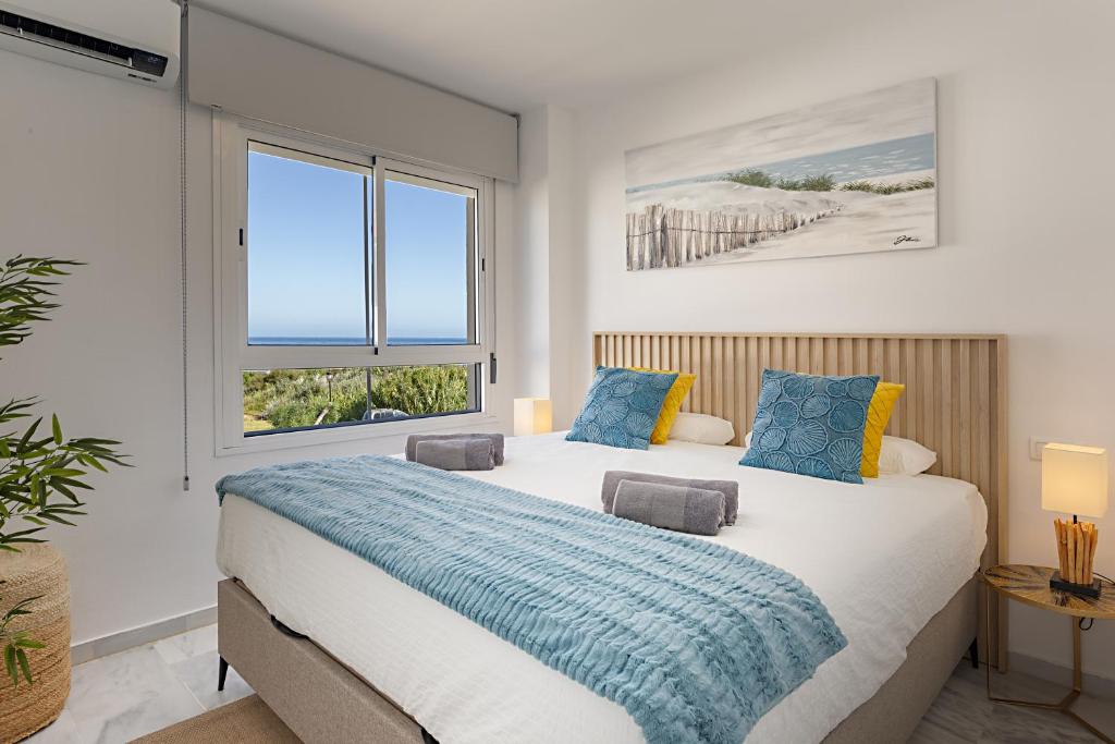 a bedroom with two beds and a window at Relax at Premium Beach flat - Aldea Beach in Manilva