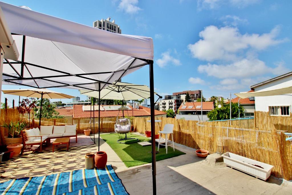 eine Terrasse mit weißem Baldachin auf dem Dach in der Unterkunft beautiful 3 rooms apartment at neve tzedek in Tel Aviv