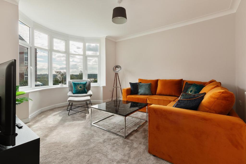 a living room with an orange couch and a table at Home away from home in Sheffield