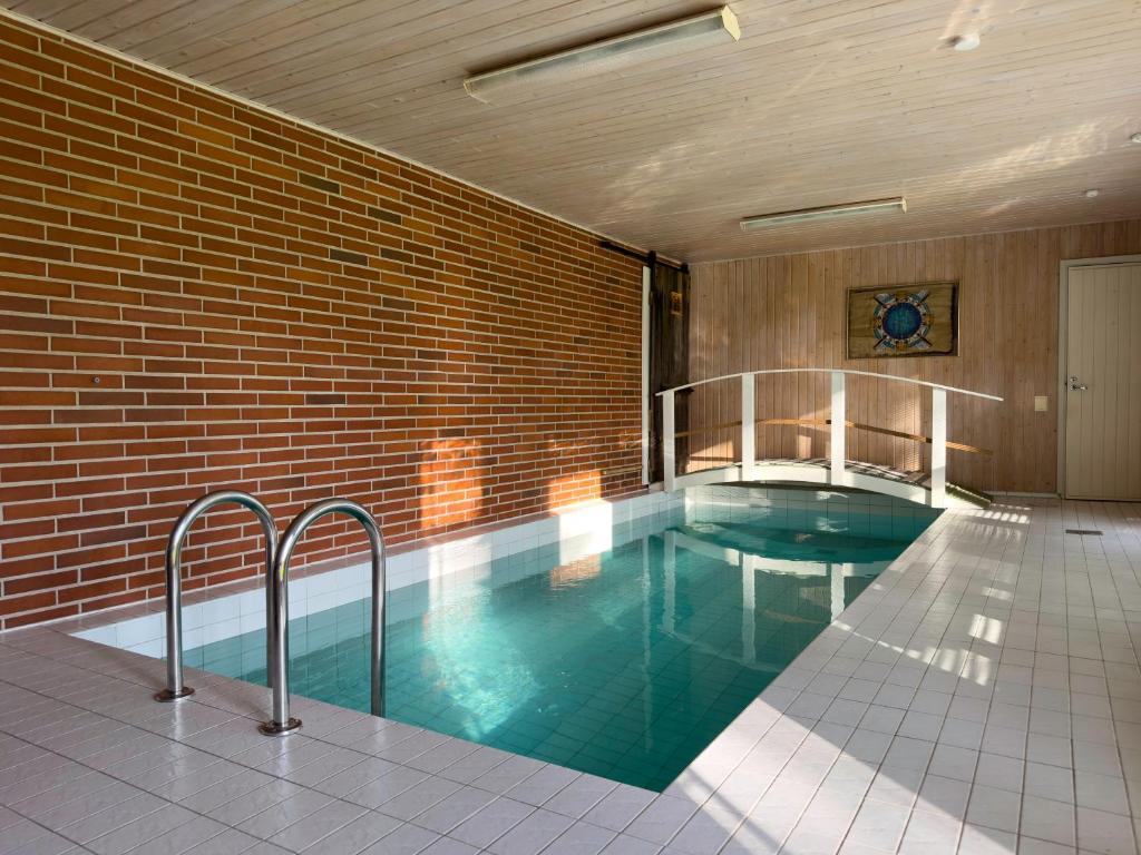 a swimming pool in a building with a brick wall at Lomatalo Honkamäki 