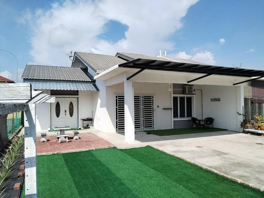 a large white house with a patio and grass at Malay Homestay di Meru, Klang in Kapar