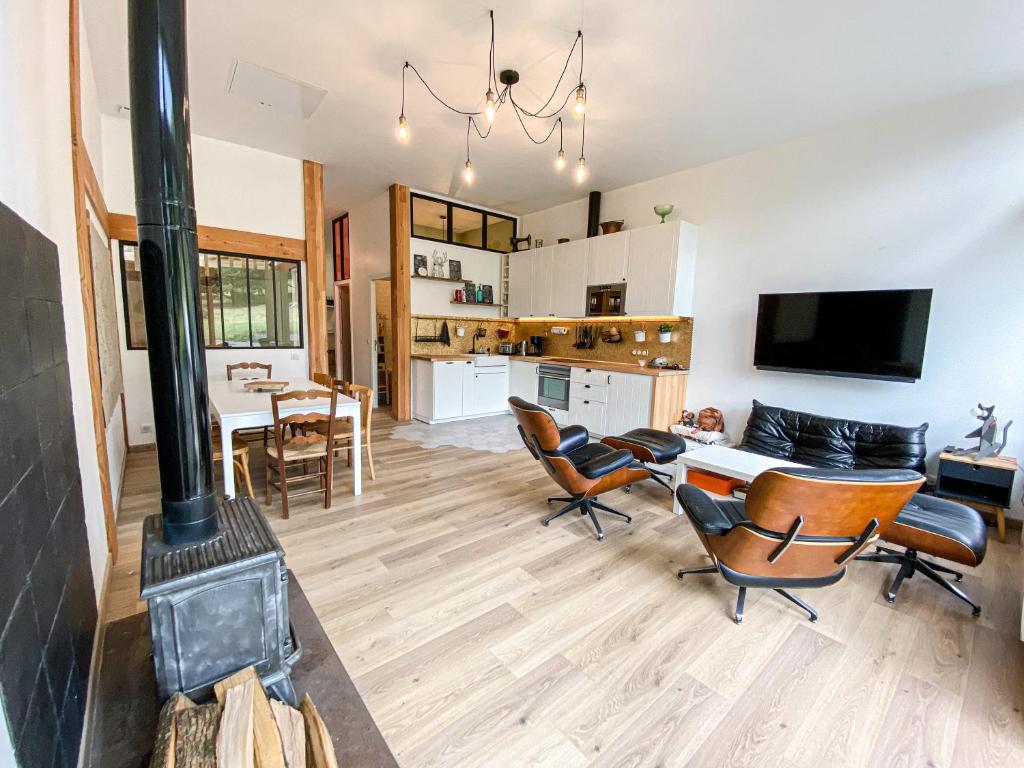 a living room with a fireplace and a table and chairs at Anouste Lou Bercail - cocon entièrement rénové avec vue sur la montagne in Campan