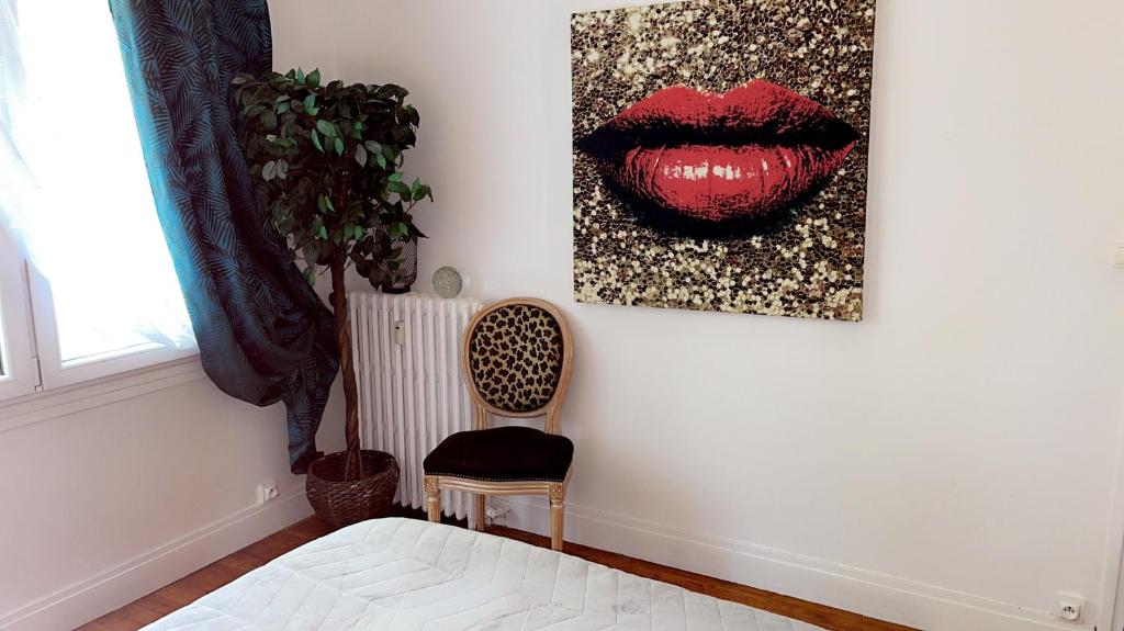a bedroom with a red lips painting on the wall at La chambre de Lou in Chatou