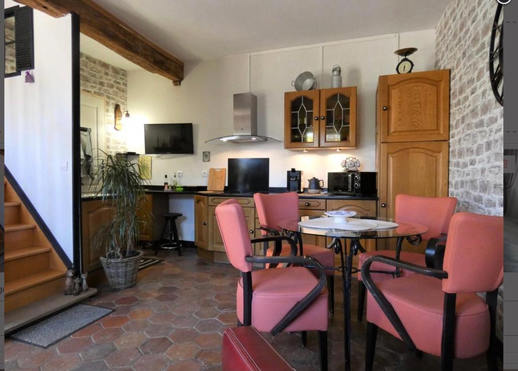 une cuisine avec une table et des chaises roses dans l'établissement La Meunière, à Jouy
