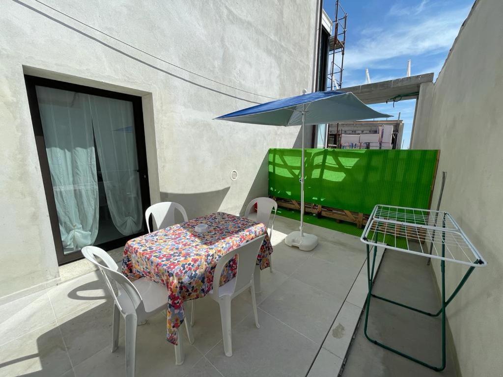 a table and chairs and an umbrella on a balcony at Crystal in Santo Stefano al Mare