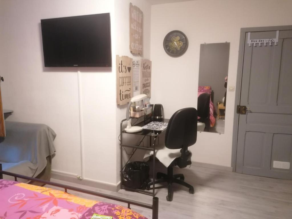 una stanza con una sedia e un computer appeso a una parete di Chambres dans maison familiale a Saint-Girons