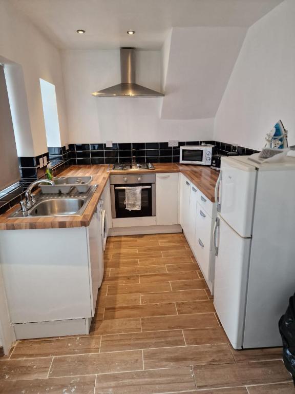 a kitchen with a sink and a white refrigerator at Luna Apartments Newcastle Gateshead 3 in Gateshead