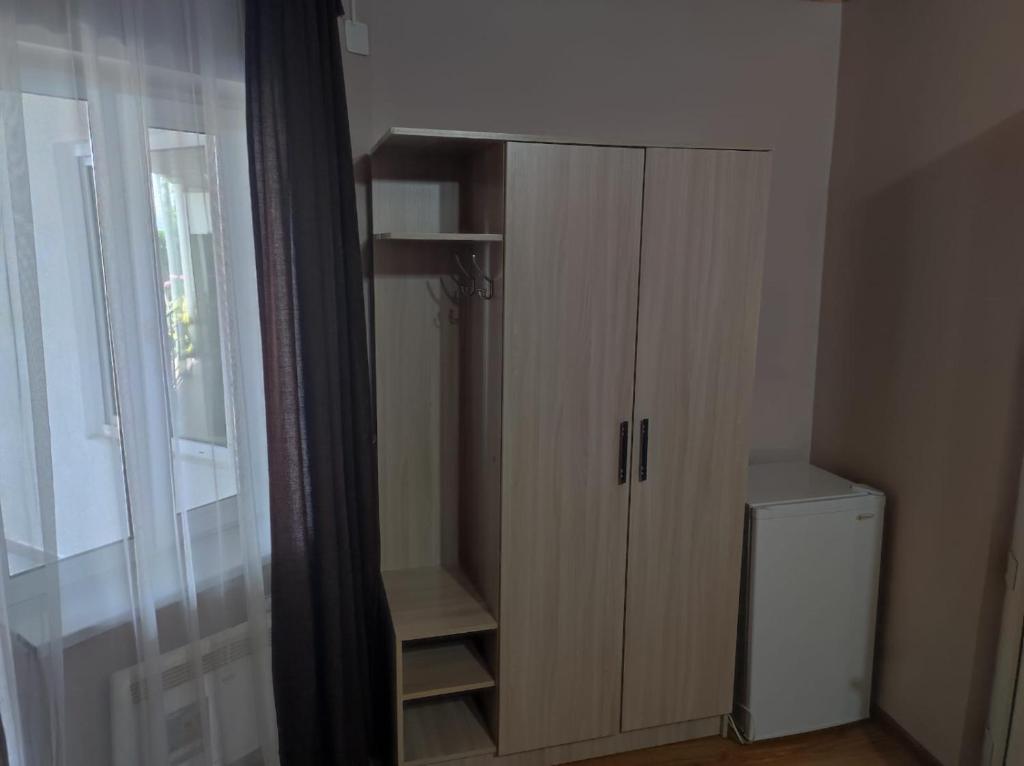 ein Schrank in einem Zimmer mit einem Fenster und einer Tür in der Unterkunft Жаркое лето на Иссык-Куле in Tscholponata