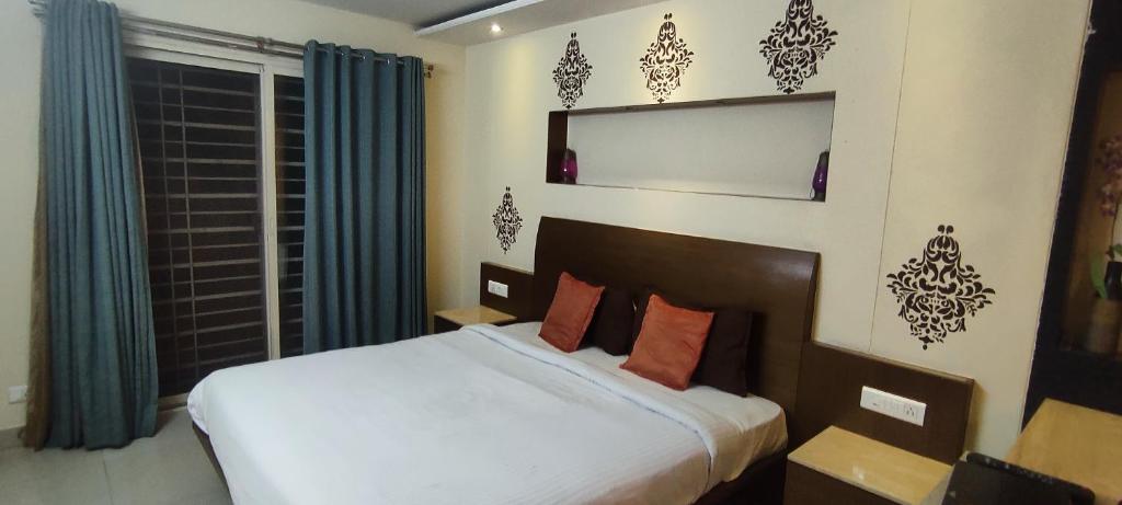 um quarto com uma grande cama branca e uma janela em Happy Vibes studio flats - service apartment em Mysore