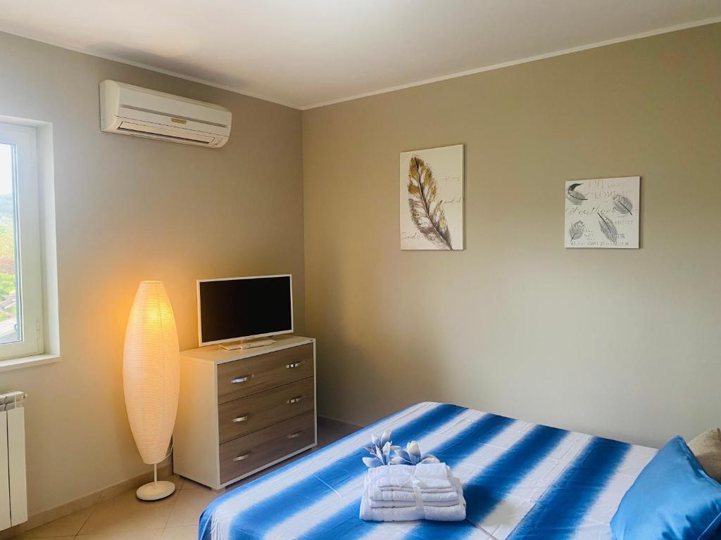 Dormitorio con cama y tocador con TV en Casa vacanze MELFA, en Atina