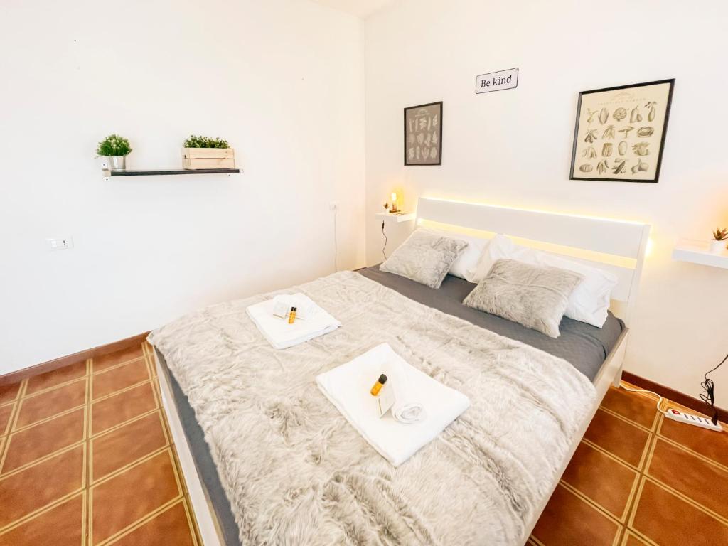 una camera da letto con un letto con due asciugamani bianchi di [Ospedale Cisanello] Bonsai House a Pisa