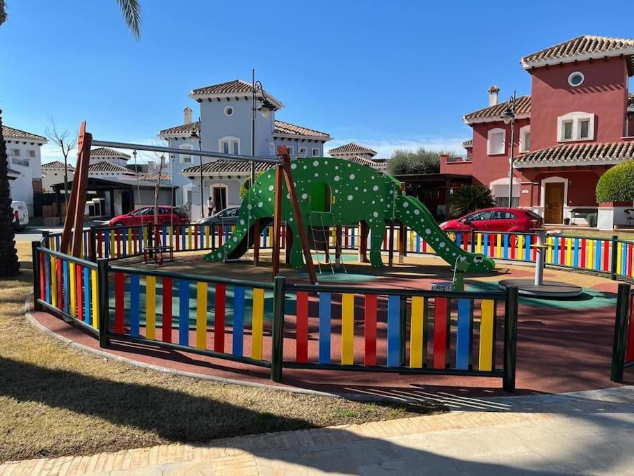 a playground with a green dinosaur on a roller coaster at Villa Alegre - 2 bed villa with private heated pool on Mar Menor Golf - family friendly in Torre-Pacheco