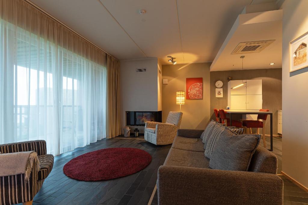 a living room with a couch and a television at HYGGE APART with fireplace at the seaside in Kuressaare