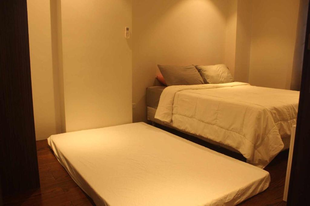 2 camas en una habitación pequeña con 2 colchas en family vacation accomodation en Maribago
