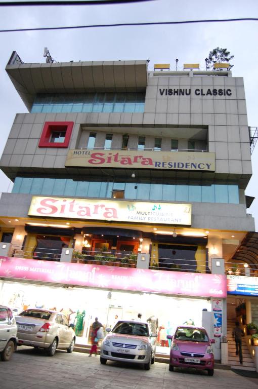 a building with cars parked in front of it at Hotel Sitara Residency in Hyderabad