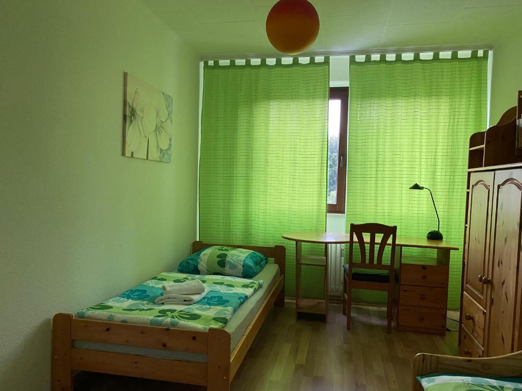 ein kleines Schlafzimmer mit einem Bett und einem Tisch in der Unterkunft Apartment Hannover Messe in Hannover