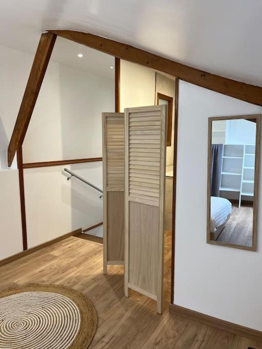 a bedroom with a mirror and a bed in a room at Petite maison de ville au calme in Brie-Comte-Robert