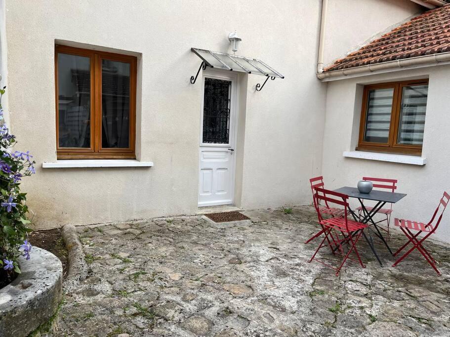 a table and chairs in front of a house at Petite maison de ville au calme in Brie-Comte-Robert