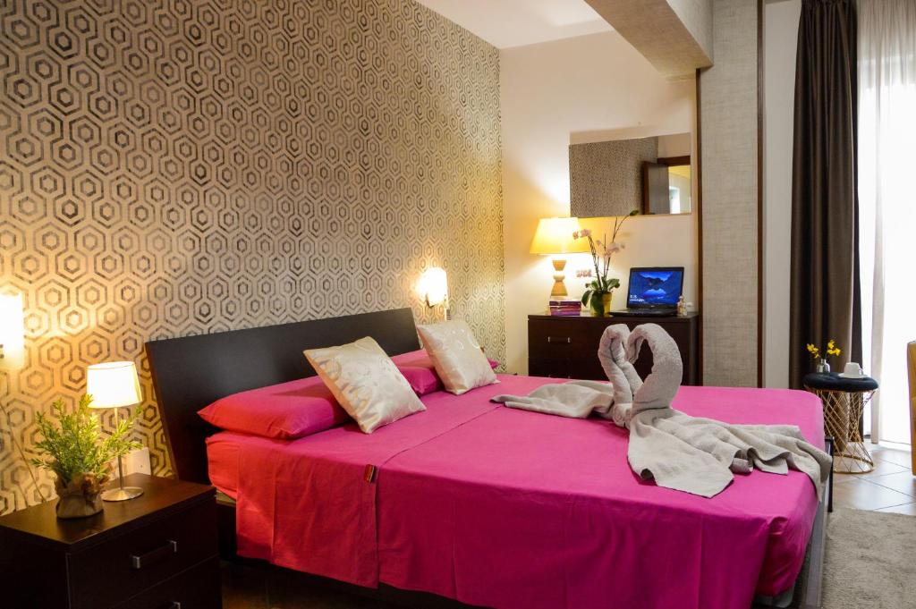 1 dormitorio con cama rosa y manta rosa en B&B Sole Luna, en Marina di Gioiosa Ionica