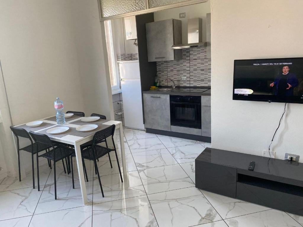eine Küche mit einem Tisch und Stühlen sowie einem TV in der Unterkunft Ritiro sul fiume Mantova, Cremona Circuit in Canneto sullʼOglio
