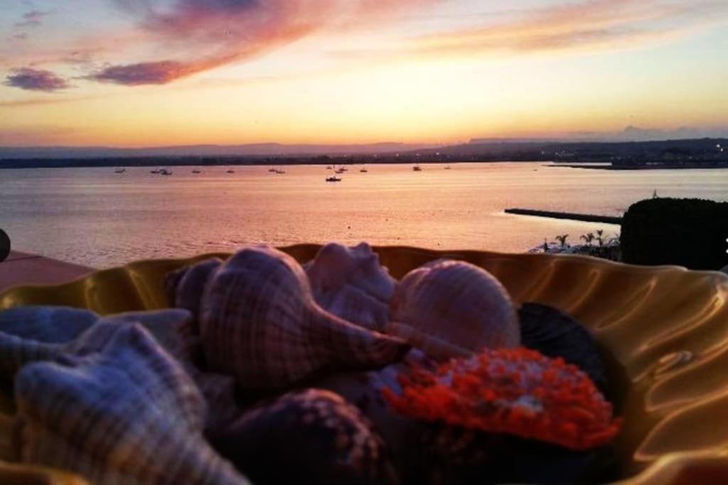 a bowl of flowers with a view of the water at Terrazza sul mare attico "Alfeo e Aretusa" in Siracusa