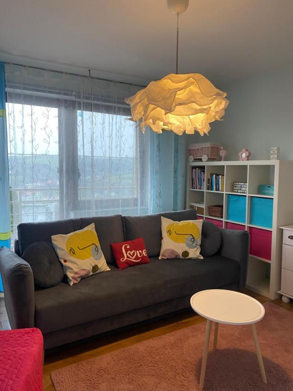 a living room with a couch with pillows on it at Apartmán Provence in Luhačovice