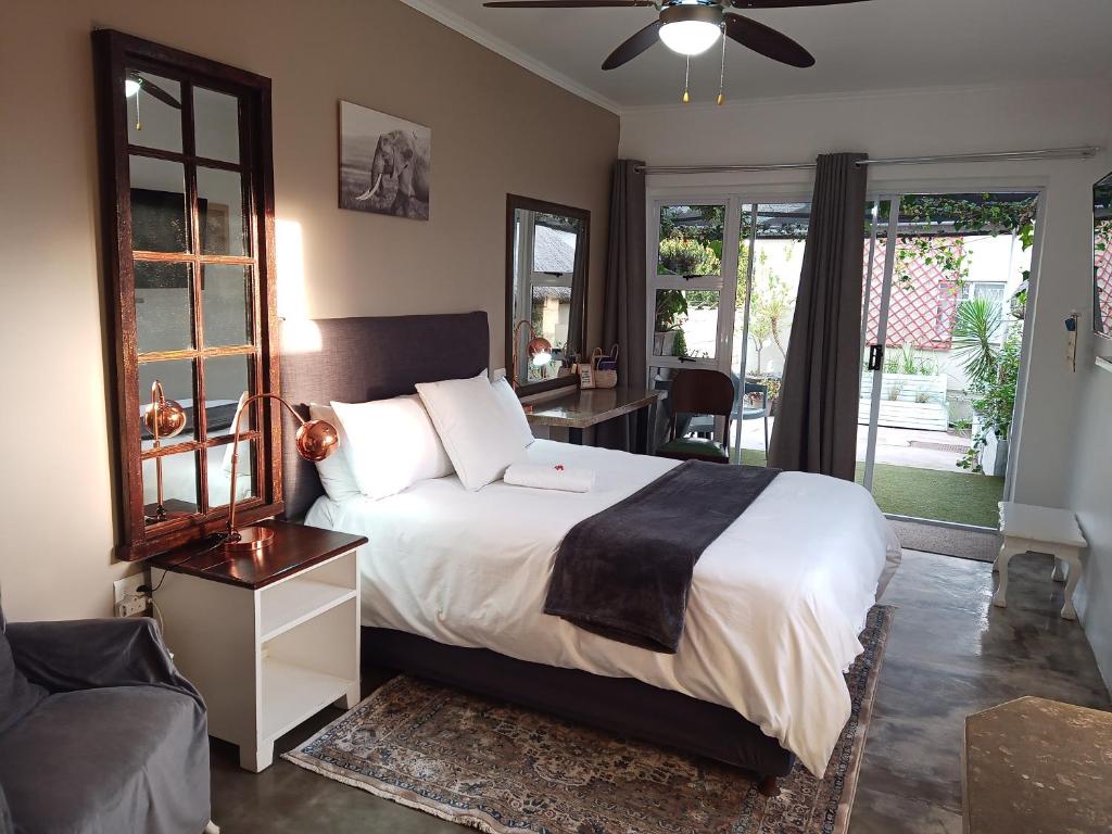 a bedroom with a bed and a couch and windows at The Oak Tree in Queenstown