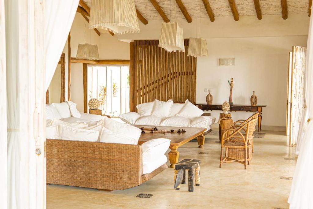 un salon avec des meubles blancs et une table dans l'établissement Casa Mandala Corumbau, à Corumbau