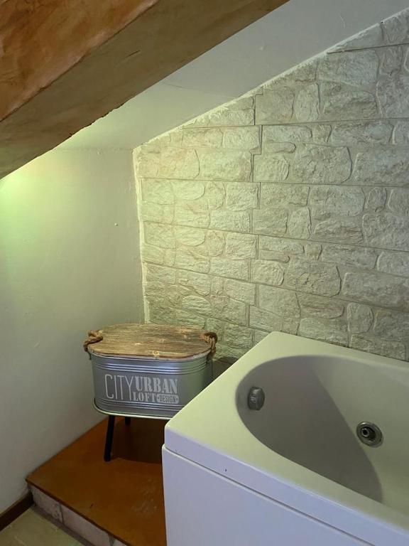 un bagno con vasca accanto a un muro di pietra di Tulipipì a Sant'Albino