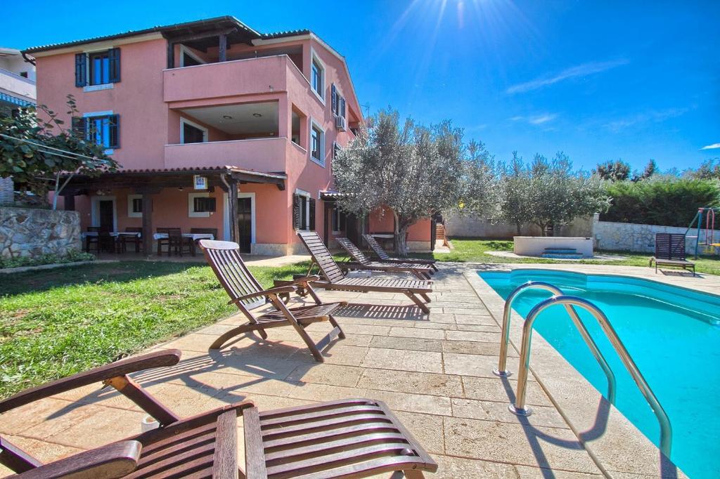 a group of chairs sitting next to a swimming pool at Traumhaft nur 400 Meter zum Strand in Banjole