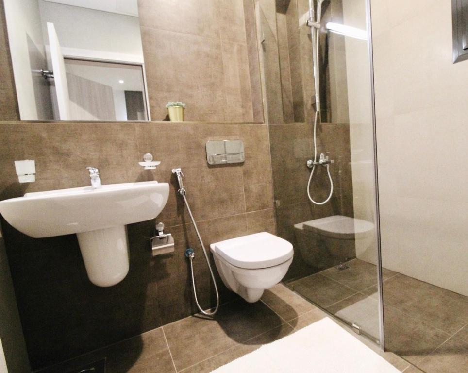 a bathroom with a toilet and a sink and a shower at Nakheel Residence Sabah Alsalem by House living in Kuwait