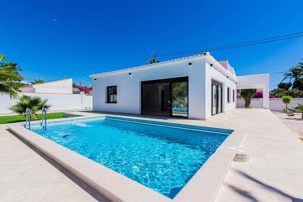 a villa with a swimming pool in front of a house at Villa MaJa Albir in Albir