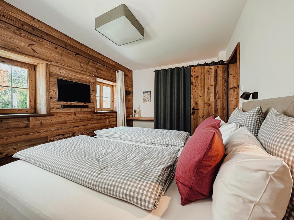 um quarto com 2 camas e uma televisão de ecrã plano em Chalet Alpin mit privatem Whirlpool und Sauna em Bayrischzell