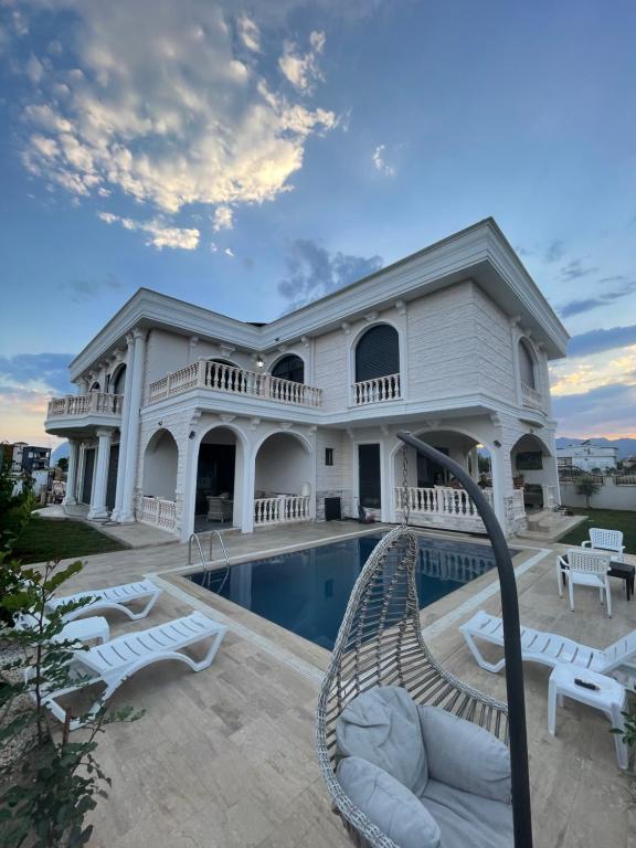 une grande maison blanche avec une piscine dans l'établissement Villa white, à Antalya