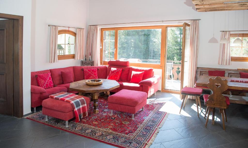 sala de estar con sofá rojo y mesa en Holiday flat with Jacuzzi for 6 persons-Lenzerheide, en Lenzerheide