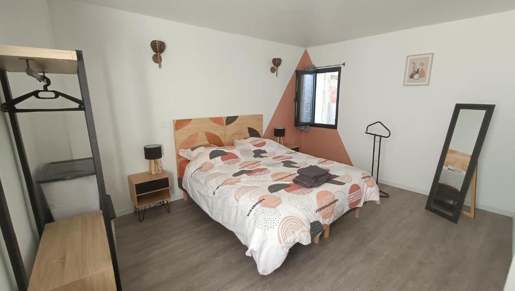 ein Schlafzimmer mit einem großen Bett und einem Spiegel in der Unterkunft Charmante maison de ville Les 2B46 in Cahors