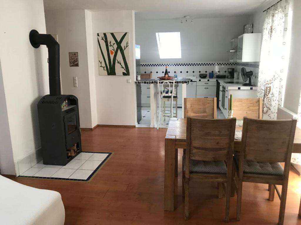 eine Küche und ein Esszimmer mit einem Holzofen in der Unterkunft Schöne Ferienwohnung im Voralpenland in Pfaffing