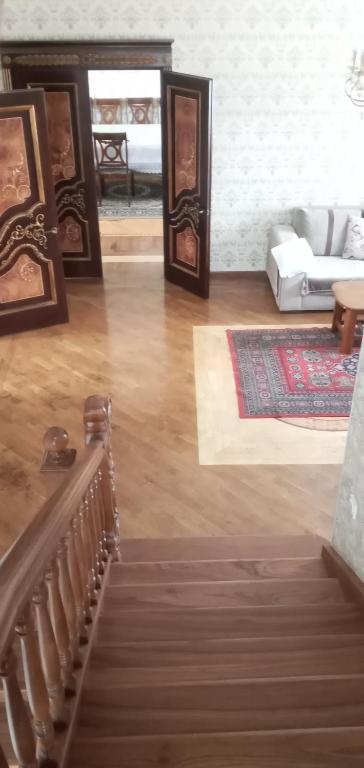 uma sala de estar com uma escada e um sofá em Уютная вилла в центре Бишкека em Bishkek