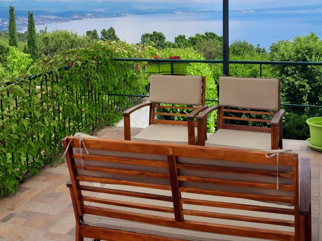 2 sillas sentadas en un patio con vistas al océano en Kuca Draga - Property Nono, en Opatija