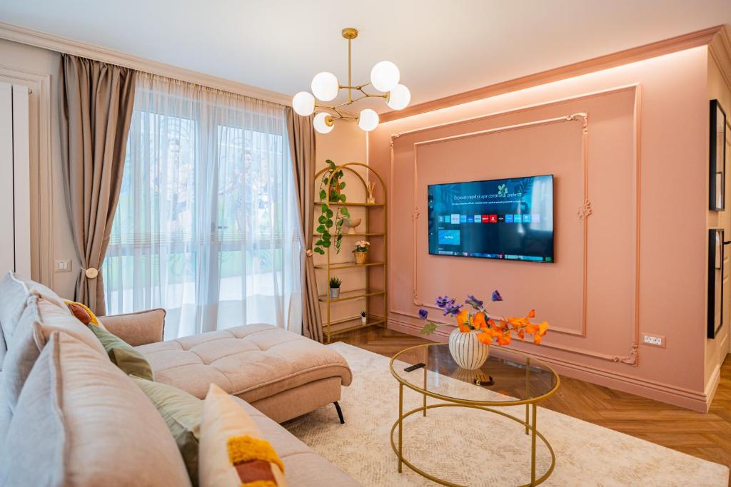 sala de estar con sofá y TV en Pink Perfection - One-Bedroom Gemstone Oasis, en Bucarest