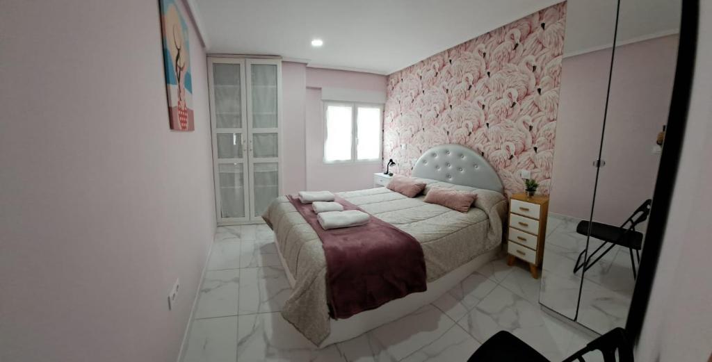 sypialnia z łóżkiem i różową ścianą w obiekcie Apartamento Zona Playa y centro Ciudad w mieście Santander