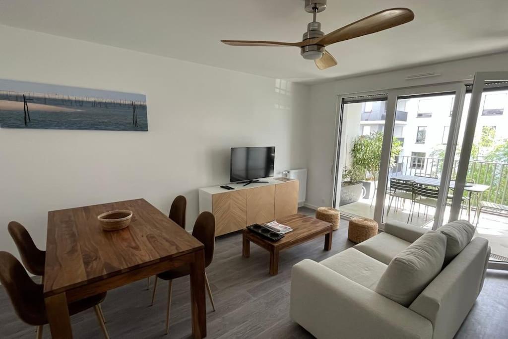 a living room with a couch and a table at Appartement cosy 80m2 au pied du tram de Bordeaux in Eysines
