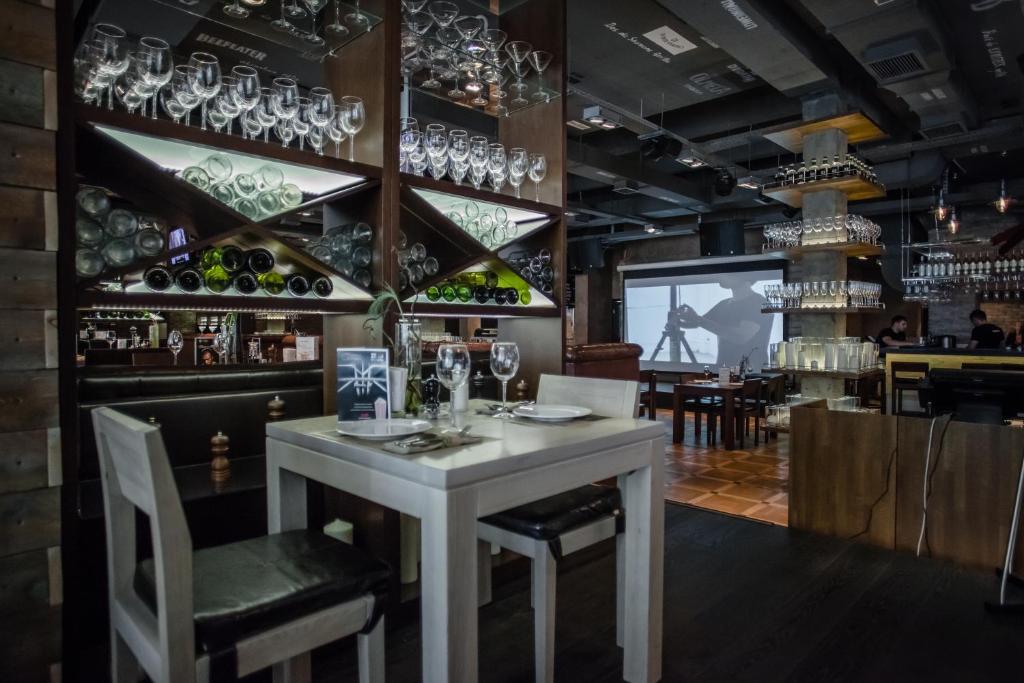 a dining room with a white table and wine glasses at AZIMUT Hotel Kemerovo in Kemerovo