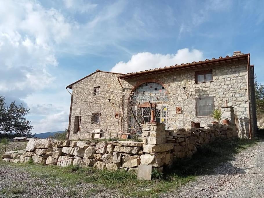 uma antiga casa de pedra com uma parede de pedra em I Ruderi di Maiano em Vaglia